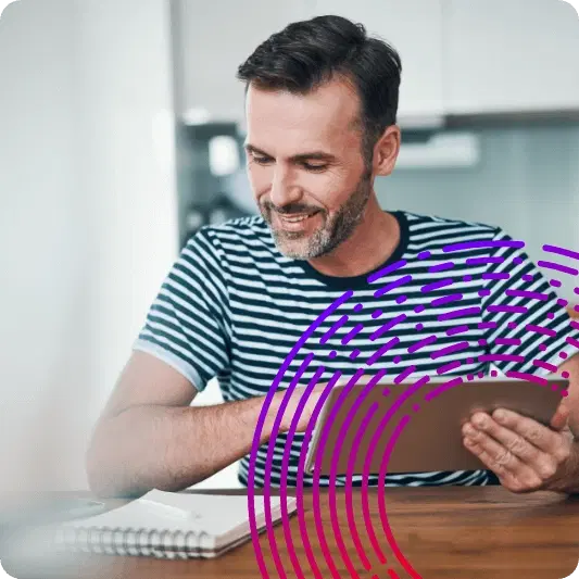 Man holding a tablet looking at a notebook